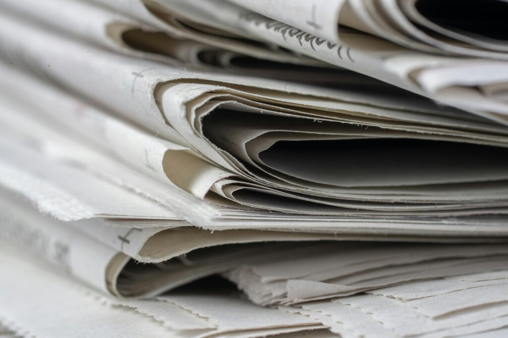 A detailed close-up view of stacked newspapers, highlighting textures and layers.