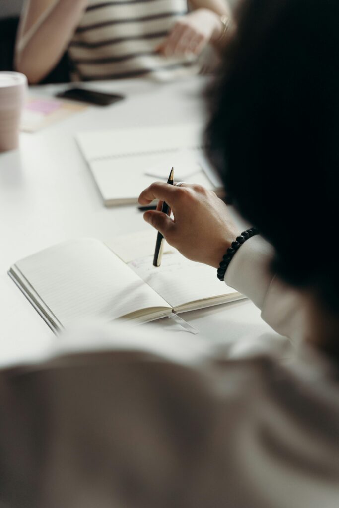 Close-up of professionals brainstorming with notebooks during a business meeting.